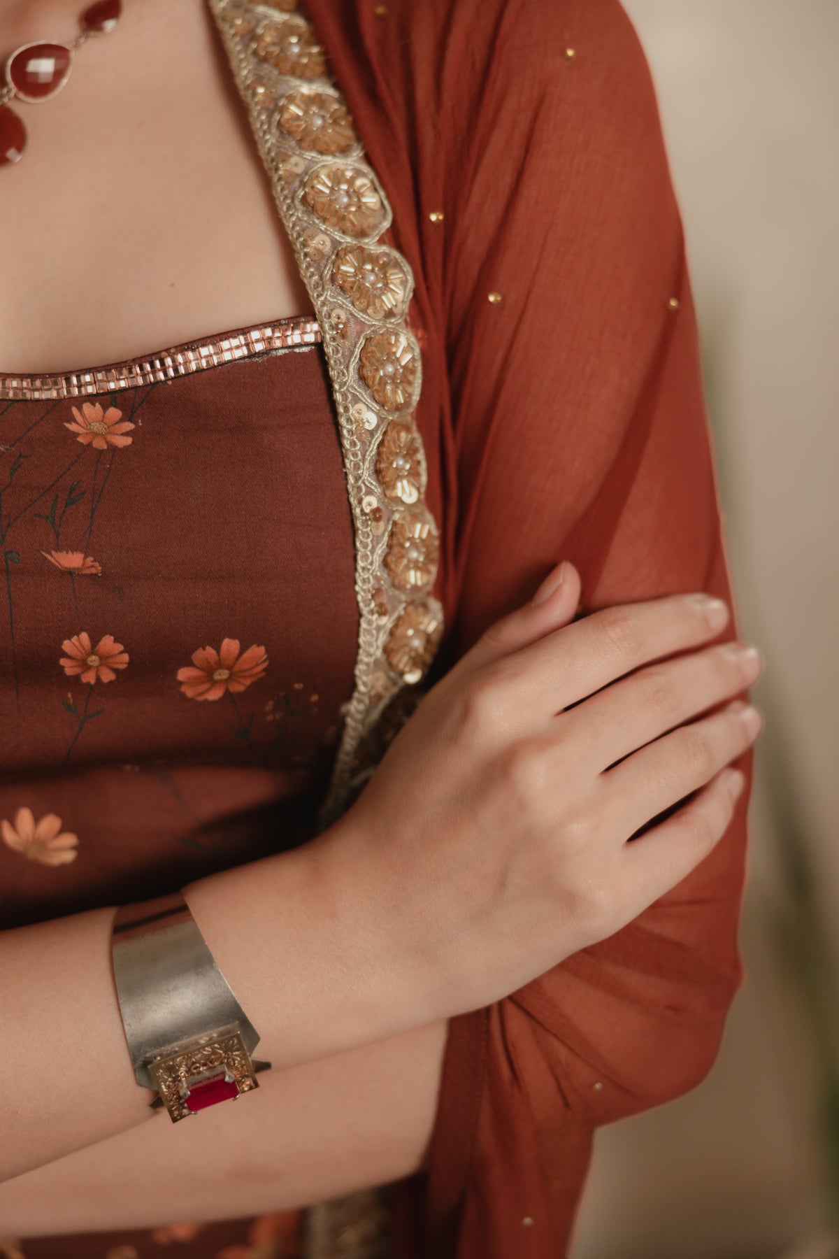 Sthira Calendula gown in vegan silk, rust-brown botanical print, detail close-up, cape dupatta gold border and bodice trim