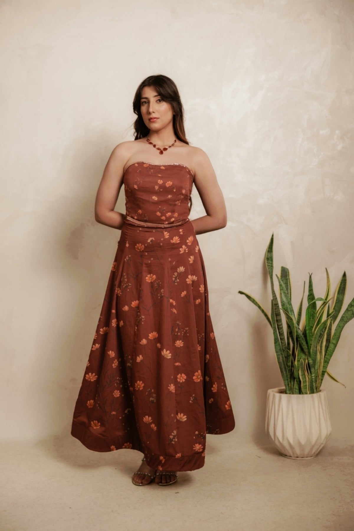 Sthira Calendula gown in warm rust-brown vegan silk with apricot blooms, worn with the sheer rust cape dupatta